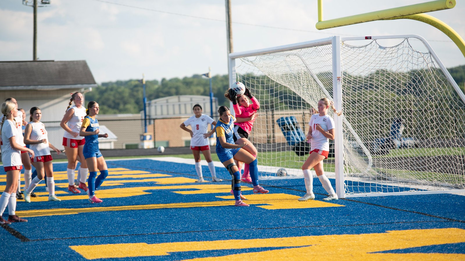 West Muskingum's Mikala Willet collides with the Lady Bishops goalie Izzy DeMattio as she makes a save.